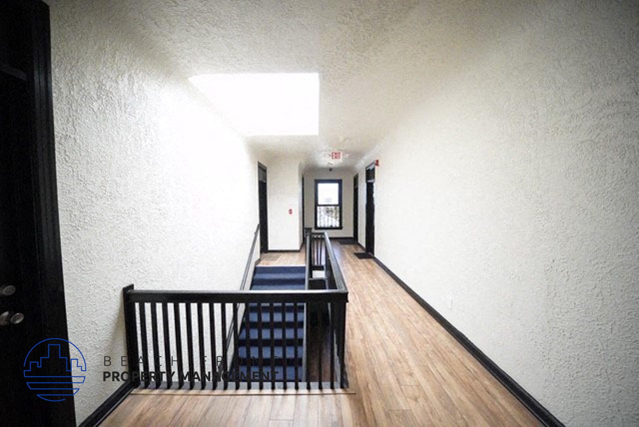 a long hallway with wood floors and a staircase